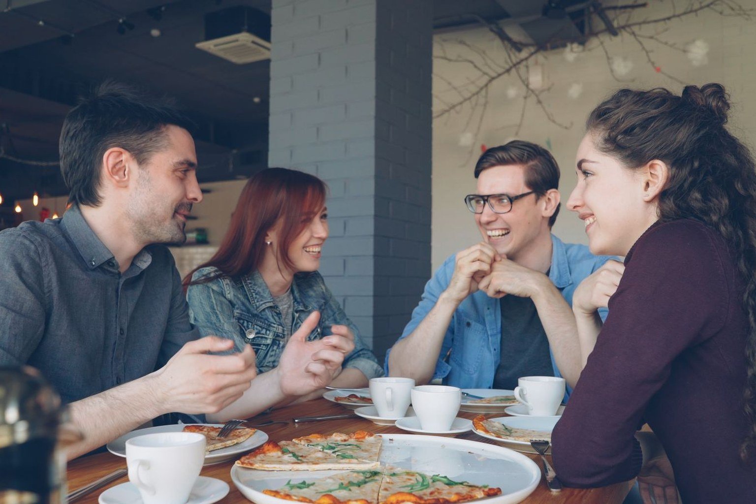 Grupo de amigos conversando animadamente en una cafetería